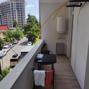 a balcony with a table and chairs on a building at Moriya in Batumi +2 photos