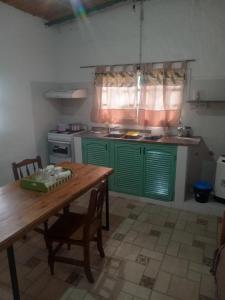 a kitchen with green cabinets and a wooden table at La casita de marga2 in Tandil