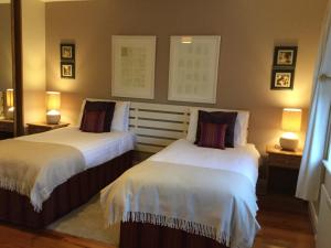 2 camas en una habitación con 2 lámparas en las mesas en Cherryville House en Portadown