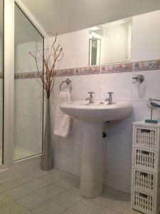 a white bathroom with a sink and a shower at Cherryville House in Portadown