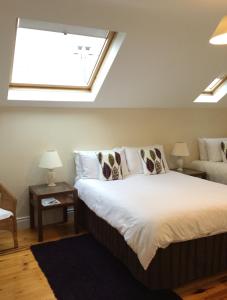 a bedroom with a large bed with a window at Cherryville House in Portadown