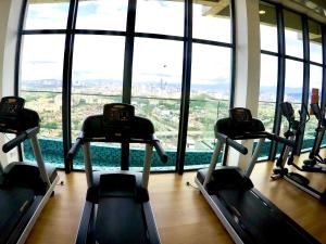 a gym with several tread machines in front of a window at EkoCheras Suites, Kuala Lumpur 1-4 Pax in Kuala Lumpur