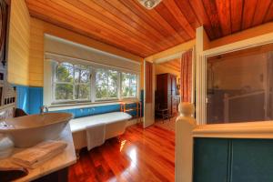 een badkamer met een groot bad en een wastafel bij Island View Spa Cottage in Smithton