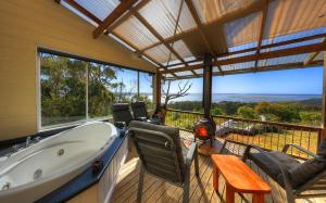 ein Badezimmer mit einer Badewanne auf einer Terrasse mit Aussicht in der Unterkunft Island View Spa Cottage in Smithton