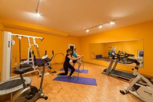 a woman exercising in a gym with exercise equipment at Hotel Bayernwinkel - Yoga & Ayurveda in Bad Wörishofen