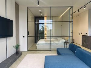 a room with a bed and a couch and a tv at PREMIUM апартаменты в парке in Pavlodar