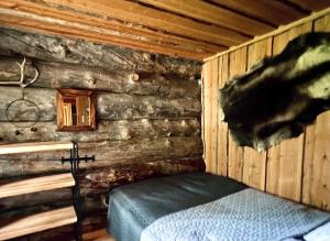 a room with a bed in a log cabin at Lapland Lodge Pyhä Ski in, sauna, free WiFi, national park - Lapland Villas in Pyhätunturi