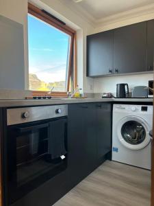 a kitchen with a sink and a washing machine at Vibrant City Center Studio Apartment 6a in Norwich