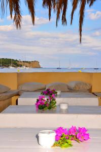 a white table topped with white flowers next to a beach at Hostal Talamanca in Talamanca