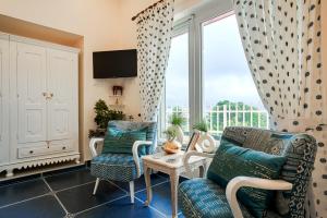 ein Wohnzimmer mit einem Sofa, Stühlen und einem Fenster in der Unterkunft SaffronStays Cottage Aaraish in Mukteswar