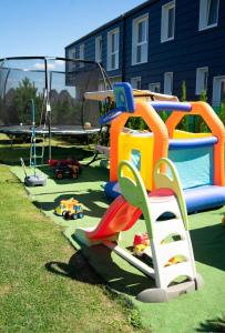 a playground with colorful play equipment on the grass at Baltic Dream Vasarnamiai in Šventoji