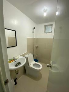 a bathroom with a toilet and a sink at JM Transient House in Butuan +3 photos