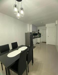 a dining room with a black table and black chairs at JM Transient House in Butuan