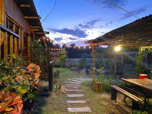 a garden at night with a table and a patio at Campista's Cabin Campsite near the Beach in Lian