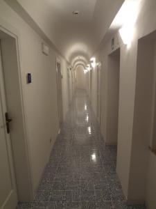 an empty hallway in a building with a long corridor at Albergo Il Monastero in Ischia
