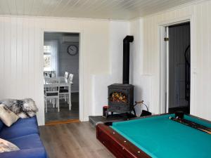 a living room with a pool table and a fireplace at 9 person holiday home in Åram in Sandvik