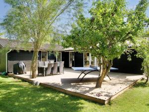 un patio con mesa, sillas y árboles en 6 person holiday home in Grevinge-By Traum, en Grevinge