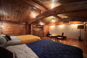 a bedroom with two beds and a table in it at The Bath and Bed Sakuho in Saku
