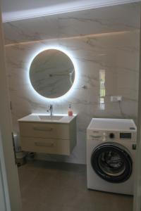 a bathroom with a sink and a washing machine at Nicole Fresh Apartments in Keramotí