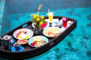 un plateau de nourriture sur une table dans une piscine dans l'établissement ANANA PRIVATE VILLA nusa penida, à Nusa Penida