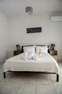 a bedroom with a white bed with two towels on it at Nicole Fresh Apartments in Keramotí