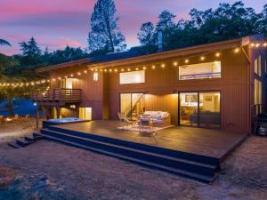 a house with a deck with a table and chairs at Yosemite Sunrise House with hot tub/views/game room! in Yosemite Forks +60 photos