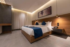 a bedroom with a large bed and a television at ارجان بارك الشفا in Riyadh