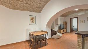 un soggiorno con tavolo, sedie e TV di Adiacente Piazza del Mercato a Spoleto