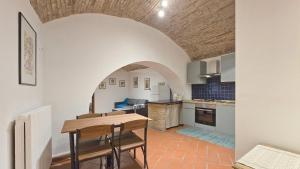 una cucina e una sala da pranzo con tavolo e sedie di Adiacente Piazza del Mercato a Spoleto Altre 17 foto