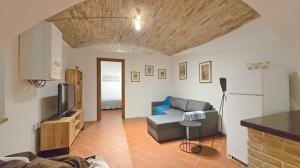 un soggiorno con divano e frigorifero di Adiacente Piazza del Mercato a Spoleto