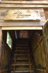 a staircase leading up to a house with a sign on it at Treehouse Velké Losiny in Velké Losiny