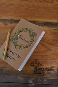 a notebook with a pen on a wooden table at Treehouse Velké Losiny in Velké Losiny