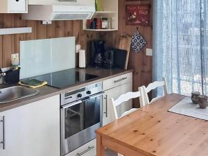 Una cocina con una mesa, una estufa y un fregadero. en 4 person holiday home in EGGEDAL, en Eggedal