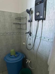 a shower in a bathroom with a blue toilet at Tubod Mar Terraza 3 bedrooms and basement up to 18 pax in Larapan