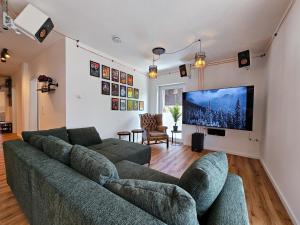a living room with a couch and a flat screen tv at BETTER l industriaI apartment l Heimkino in Altusried