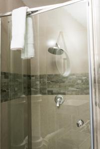 a shower with a glass door and a sink at Oceanic Unit 99 - North Beach in Durban