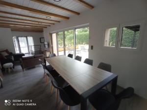 a dining room with a wooden table and chairs at Entre 2 eaux in Embrun