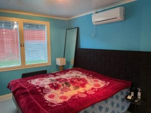 a bedroom with a bed with a red blanket on it at Sweet House with Sauna in Lieto
