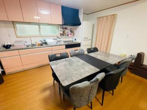 a kitchen with a table and chairs in a room at Y'sハウス in Chitose