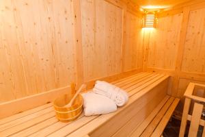 una sauna de madera con toallas y una cesta. en Salzburg-Chalet, en Grossgmain