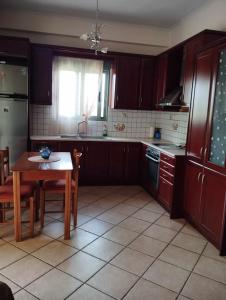 a kitchen with wooden cabinets and a table and a window at Studio eva in Palouki