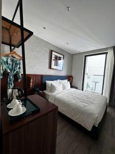 a hotel room with a bed and a desk with a table at HL Houses Apec Phú Yên in Tuy Hoa
