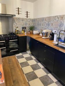 a kitchen with black appliances and a checkered floor at Appartement du sud in Saint-André-de-Sangonis