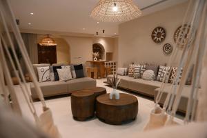 a living room with a couch and two wooden tables at Umm Al Quwain Beach Hotel in Umm Al Quwain