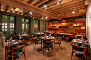 a restaurant with tables and chairs in a room at Ghent Marriott Hotel in Ghent