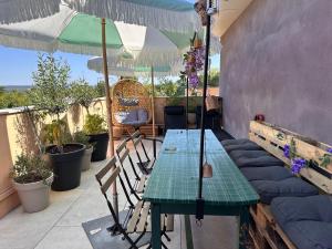 普罗旺斯艾克斯Joli Studio le clos d'Aix avec grande terrasse piscine et parking gratuit的带桌椅和遮阳伞的露台