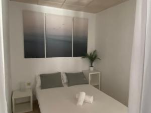 a white bedroom with a bed and a plant at Aeropuerto-Churriana-Golf in Málaga