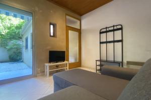 a living room with a couch and a television at Havre de paix 6 pers Bordeaux Chartrons in Bordeaux