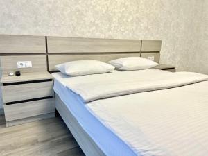 a bedroom with a large bed with white sheets and pillows at ApartPoltava Нові апартаменти ремонт цього року ПАНОРАМА, Корпусний парк, Найкраща локація in Poltava