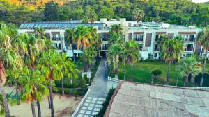 une vue aérienne d'un grand bâtiment avec des palmiers dans l'établissement Green Bay Resort & Spa - Ultra All Inclusive, à Guvercinlik